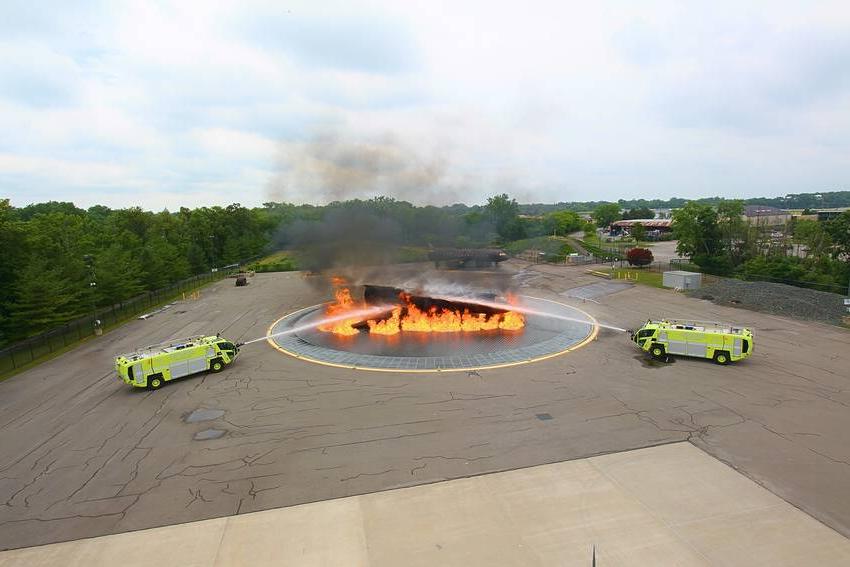 燃烧的燃料从飞机上溢出，两辆消防车正在喷洒